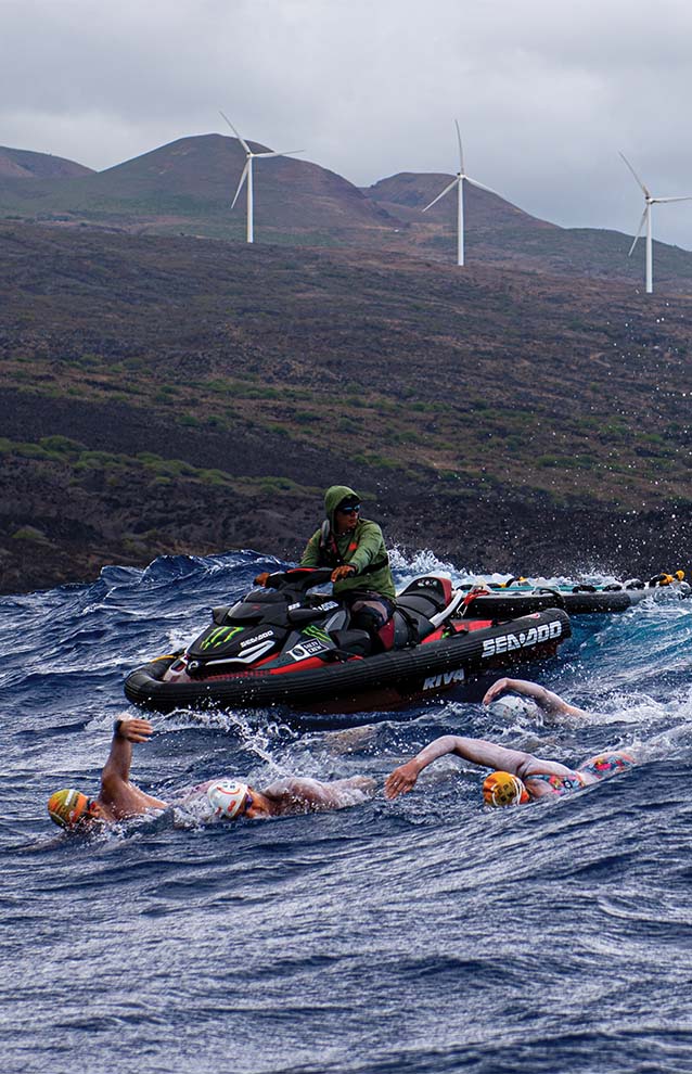 a person on a jet ski surrounded by people swimming