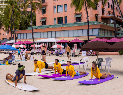 a group of people on separate surf boards on a beach